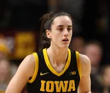 Caitlin Clark with her hair tied back in a black Iowa jersey during a game in February 2024