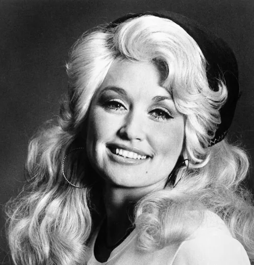 Dolly Parton smiling with voluminous blonde hair in a black-and-white RCA publicity photograph