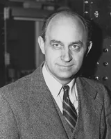 Enrico Fermi standing in front of laboratory control equipment in a photograph from the 1940s