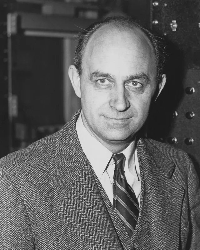 Enrico Fermi standing in front of laboratory control equipment in a photograph from the 1940s