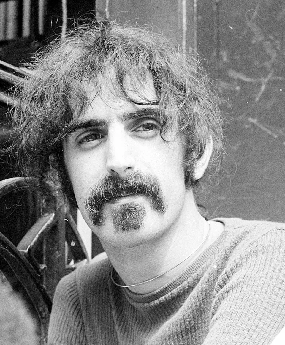 Frank Zappa with a mustache and a goatee in a black-and-white photograph from June 1970