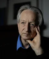 Geoffrey Hinton resting his head on his hand, photographed in May 2026