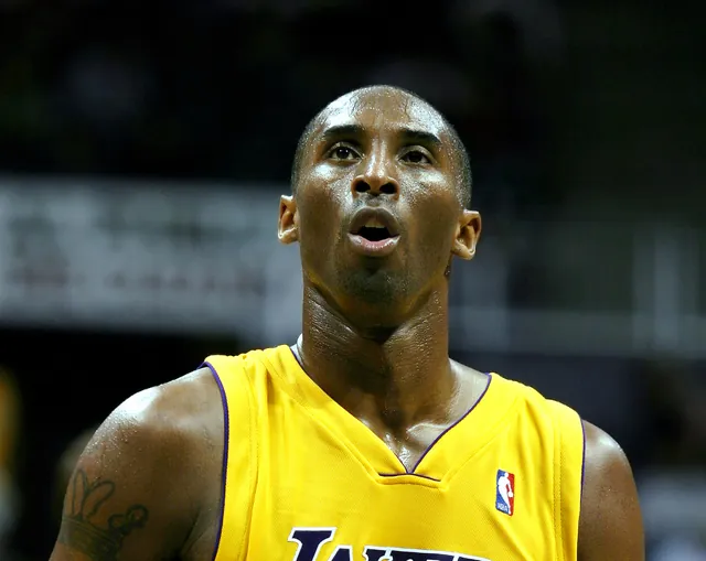 Kobe Bryant in a gold Los Angeles Lakers jersey looking upward before a free throw in an October 2005 pre-season game