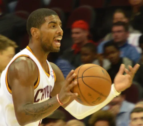 Kyrie Irving in a white Cleveland Cavaliers jersey holding a basketball during a game in October 2013
