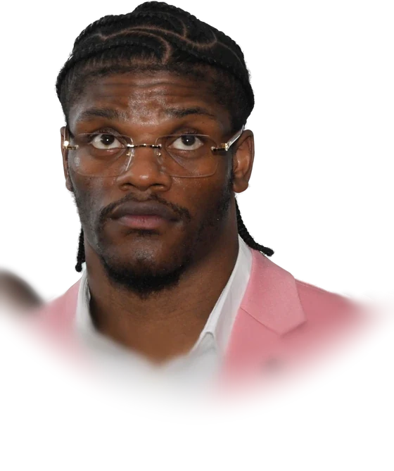 Lamar Jackson in wire-rimmed glasses and a pink blazer looking at the camera in May 2024
