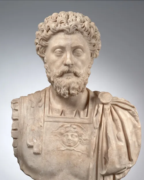 Marble bust of the Roman emperor Marcus Aurelius with curly hair and a full beard, wearing a cuirass with a Medusa head and a cloak over the shoulder