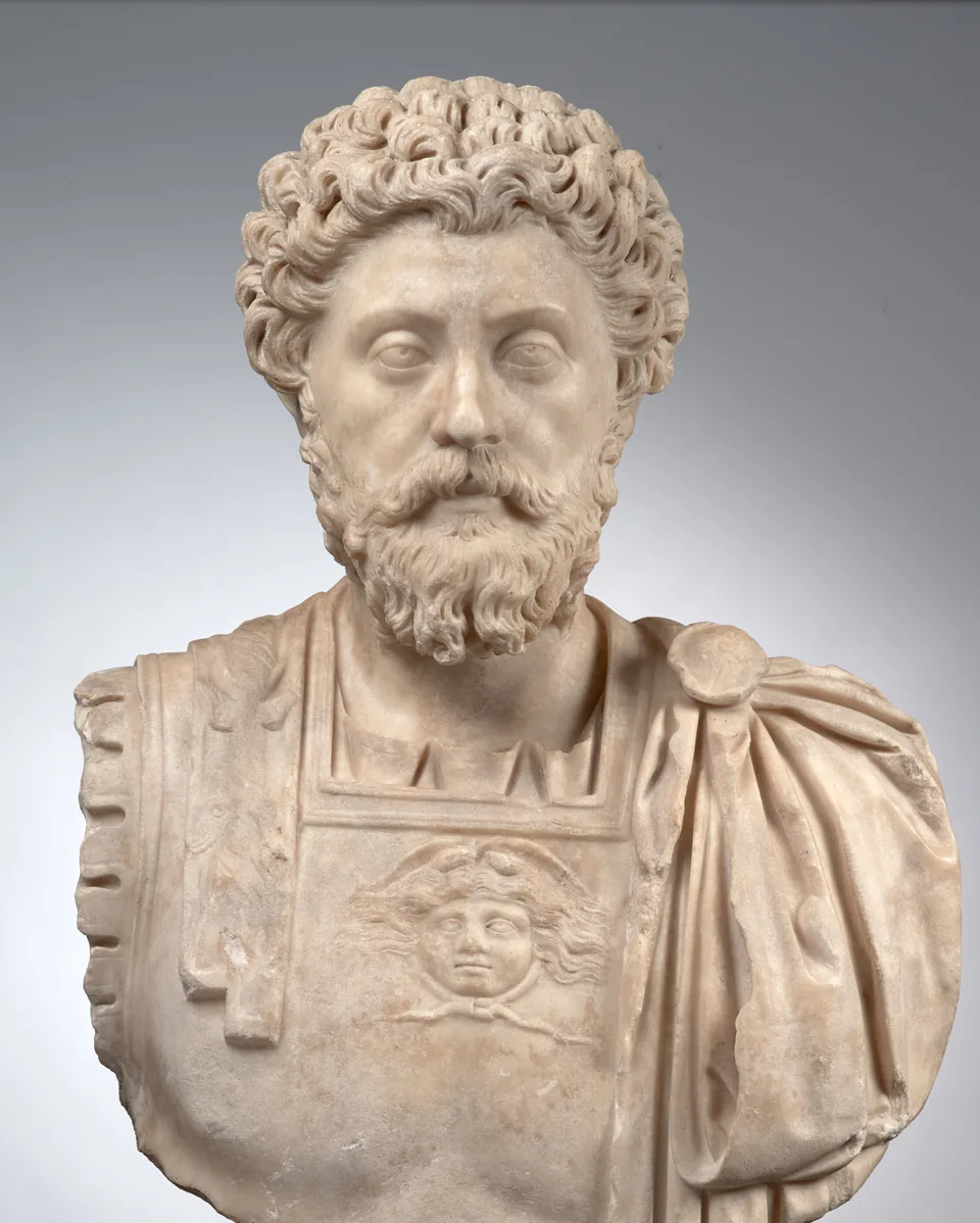 Marble bust of the Roman emperor Marcus Aurelius with curly hair and a full beard, wearing a cuirass with a Medusa head and a cloak over the shoulder