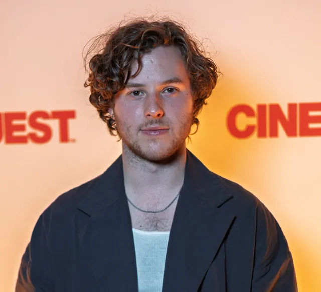Nolan Gould, the actor who played Luke Dunphy on Modern Family, with curly hair and a dark open coat over a light blue top, at the Cinequest Film Festival in March 2026