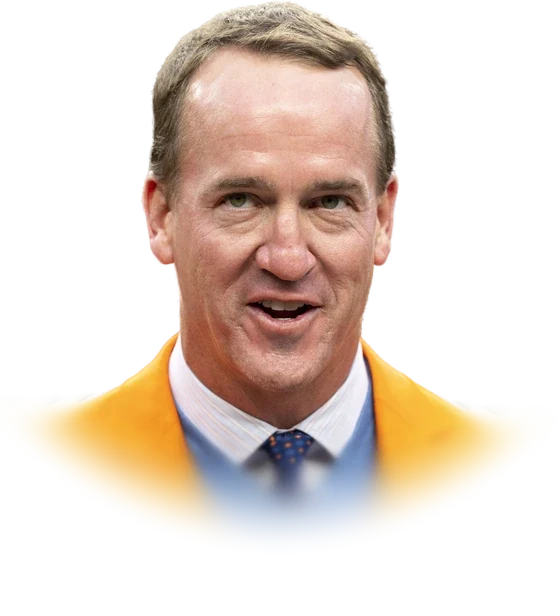 Peyton Manning in an orange blazer and a blue sweater speaking at a Denver Broncos game in October 2021