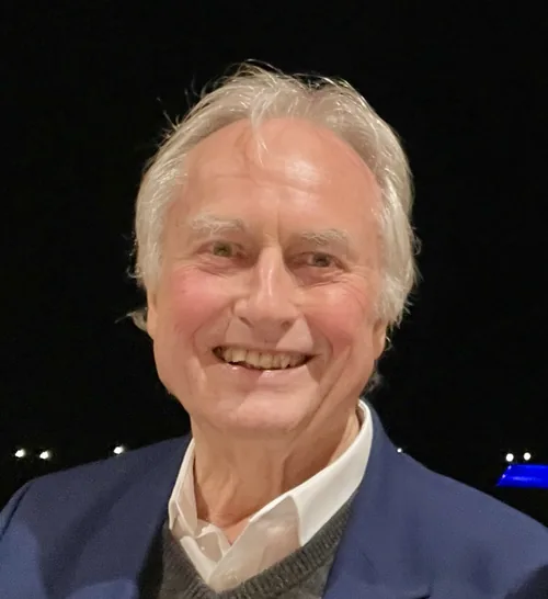 Richard Dawkins smiling in a blue jacket, photographed at a dinner in October 2022