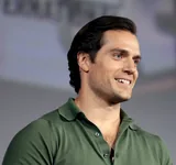 Henry Cavill, the actor who played Superman in the 2013 film Man of Steel, smiling in a green polo shirt at San Diego Comic-Con in July 2019