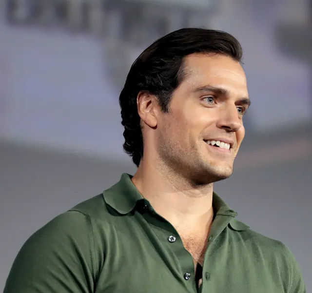 Henry Cavill, the actor who played Superman in the 2013 film Man of Steel, smiling in a green polo shirt at San Diego Comic-Con in July 2019