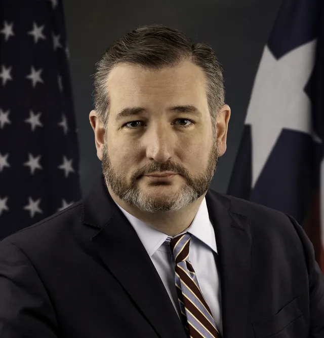 Ted Cruz with a trimmed dark beard in a dark suit, white shirt and striped tie, in his official U.S. Senate portrait from January 2019
